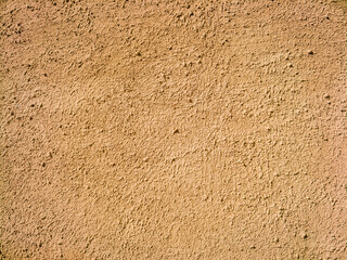 Rough plastered wall texture or background in light earthy tone