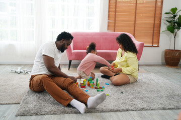 Shot of happy interracial family of mother father and their daughter inside modern apartment.