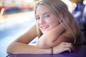 Obraz premium Blonde young woman against wall background, smiling and posing outdoor