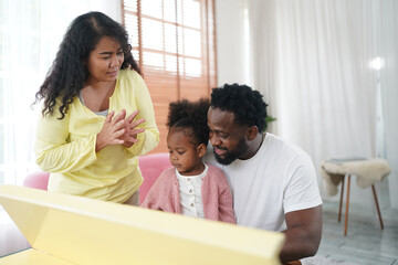 Shot of happy interracial family of mother father and their daughter inside modern apartment.