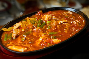 Vegetable ragout with pork pieces in a cast iron dish