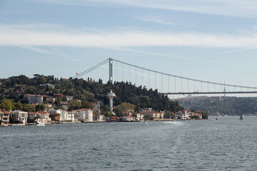 View of boats passing on Bosphorus, Kanlica neighborhood and FSM bridge in Istanbul. It is a sunny summer day. Beautiful travel scene.
