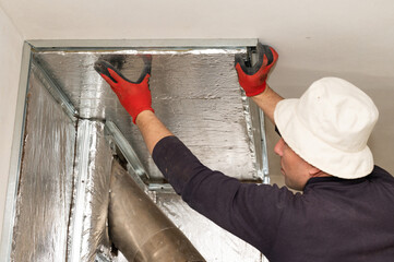 Mineral wool with foil, thermal protection for the wall from the fireplace, installation of metal beacons, screwing the beacons to the wall with a screwdriver.