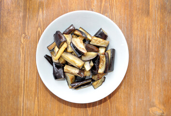 dish with baked eggplant on wooden background