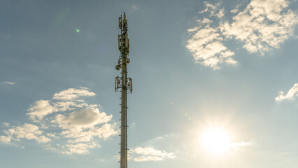 Obraz premium New GSM antennas on a high tower against a blue sky for transmitting a 5g signal are dangerous to health. Radiation pollution of the environment through cell towers. The threat of extinction