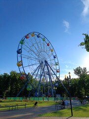 Attraction is the wheel of review on background blue sky. Ferris wheel in retro vintage style