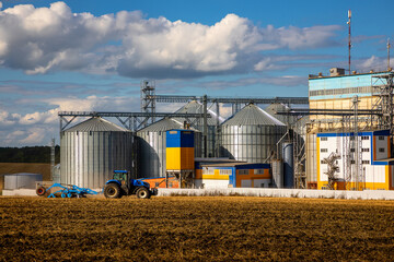 Agricultural Silos. Storage and drying of grains, wheat, corn, soy, sunflower against the blue sky with white clouds.Storage of the crop