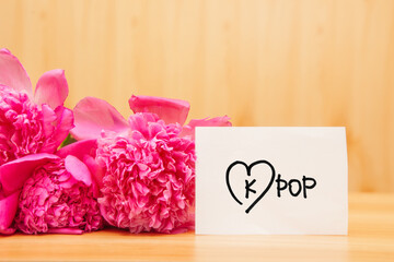 Kpop - korean pop music concept, card with lettering and heart and peony flowers bouquet