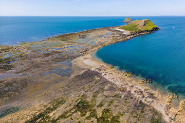 Aerial view of a causeway connecting the mainland to an island at low tide (Worm's Head, Wales)