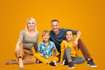 Happy father and mother with little children sitting