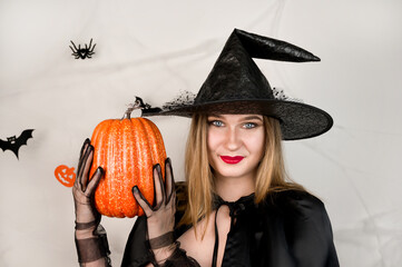 Autumn holidays banner with cute witch holding pumpkin on white background,. October 31 concept.Halloween party