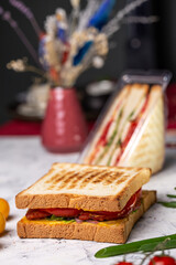 juicy crispy sandwich with ham and vegetables close-up on the board