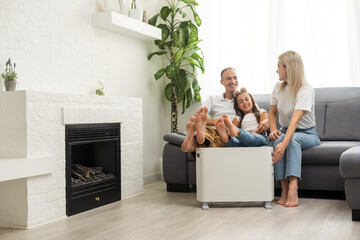 Family warming up near home heater at winter cold time. The symbolic image of the heating season at...