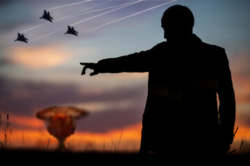 Fototapeta na wymiar The concept of a nuclear strike. Silhouette of fighters and a man who points forward with his hand to attack. A politician who started a nuclear war