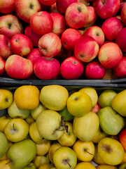fresh yellow and red apples in plastic boxes on the counter in the supermarket