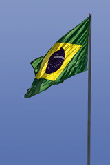 A bandeira do Brasil. Bandeira do Brasil voando, tremulando ao vento e com o céu azul ao fundo.