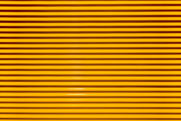 Obraz premium Yellow fluted metal corrugated metal texture, ribbed metallic surface, wavy iron wall pattern.