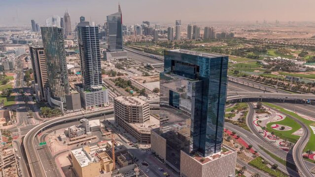 Aerial view of media city and al barsha heights district with golf course timelapse during all day from Dubai marina with shadows moving fast. Towers and skyscrapers with traffic on a highway from
