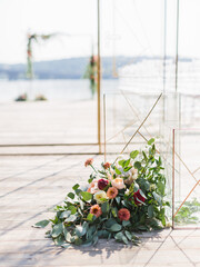 Wedding floral decor on a wooden floor in gentle tones. A bouquet of proteas, beige peonies, cream...