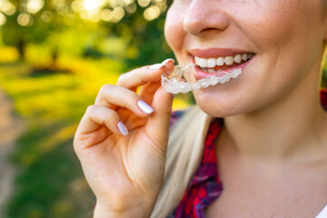 Dental Treatment Concept. Close up of young woman holding invisible aligner, whitening tray, free space