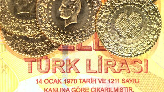 Pile of Turkish gold coins on paper money background. Money and gold tucked away under a pillow during financial crisis. Close up
