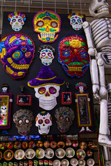 wall with souvenirs for tourists and hanging adornments of traditional catrinas and skulls and skeletons for halloween and day of the dead in mexico