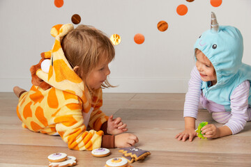 Cute little girls in giraffe and narwhal costume play at home. Halloween party © Darya Lavinskaya