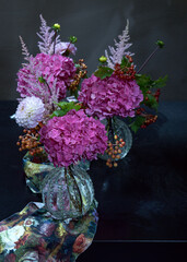 Beautiful purple hydrangea flowers in a vase on a table.Delicate floral arrangement. Close-up...