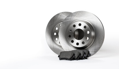 New brake discs and pads stand on a white background. copyspace.