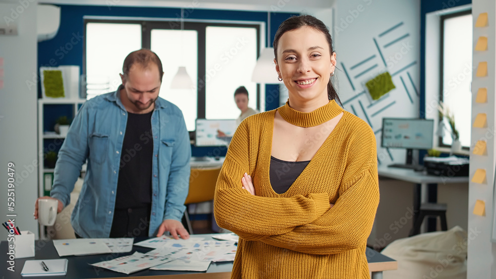 Aufkleber portrait of confident startup employee entering frame posing with arms crossed and smiling in busy m