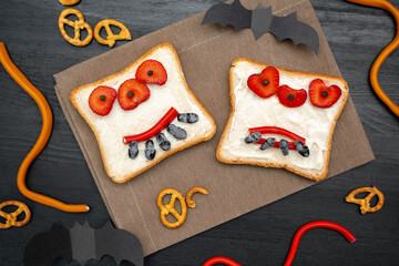 Funny monster face on halloween sandwich toast bread with butter, strawberry, sweets,cutting...