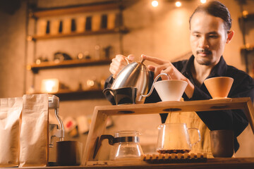 hipster barista pouring a hot water to making coffee with drip or filter style in cafe, slow brew for caffeine aroma beverage drink in cup, fresh black coffee and espresso for breakfast