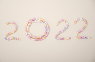 Obraz premium figures of the year 2022 lined with pastel colors candies lettering