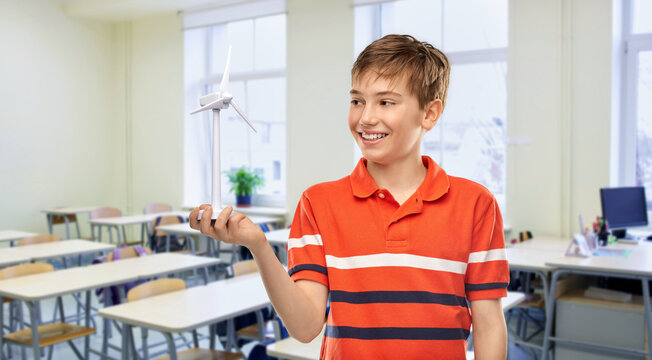 education, school and people concept - portrait of happy smiling boy in red polo t-shirt with toy wind turbine over classroom background - Powered by Adobe