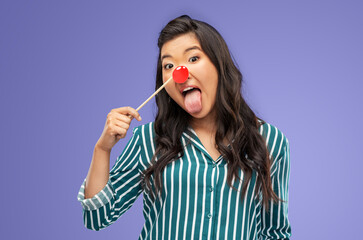 red nose day, party props and photo booth concept concept - funny woman with clown nose sticking...