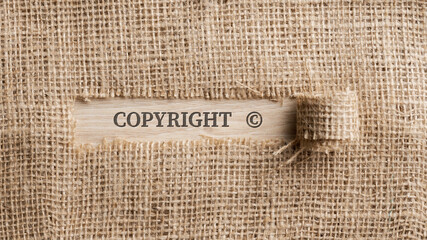 Rough linen fabric with a torn section in which the word Copyright is written