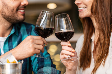 leisure, drinks and people concept - close up of happy couple drinking red wine at restaurant