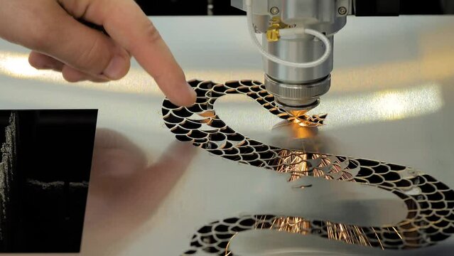 Close up - cnc laser cutting machine working with sheet metal with sparks at factory, plant. Metalworking, machining, industrial, equipment, technology, manufacturing concept