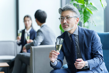 パーティーで雑談をするシニアビジネスマン