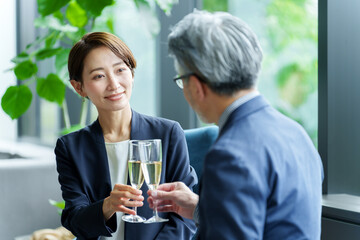 スパークリングワインを飲みながら雑談をするビジネスパーソン