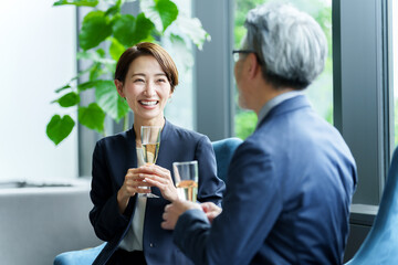 スパークリングワインを飲みながら雑談をするビジネスパーソン