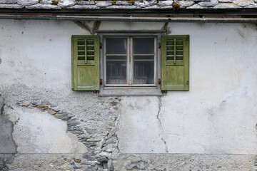 Books in a traditional european window with green shutters, Splügen, Switzerland