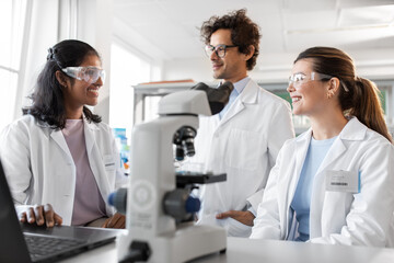 science research, work and people concept - international team of scientists with laptop computer...