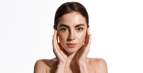 Beauty face and spa. Woman with freckles, clean nourished skin, biting lip and look aside. Girl...