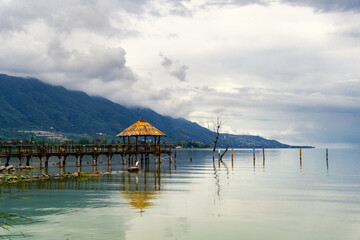 beautiful pier on a lake with mountains on background
