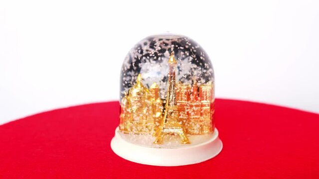 PARIS, france - december 2021: glass ball with snow, christmas souvenir in the form of a transparent sphere containing a model of Paris landmarks, eiffel tower, notre dumme with artificial snow
