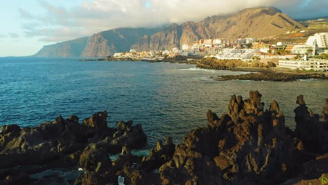 Tenerife, Canary Island, town Puerto de Santiago, Charco el Diablo or natural pool of Devil. Black lava flows, volcanic bizzare stones, rocky beach, Atlantic Ocean. Scenic spot. Amazing nature. Aerial