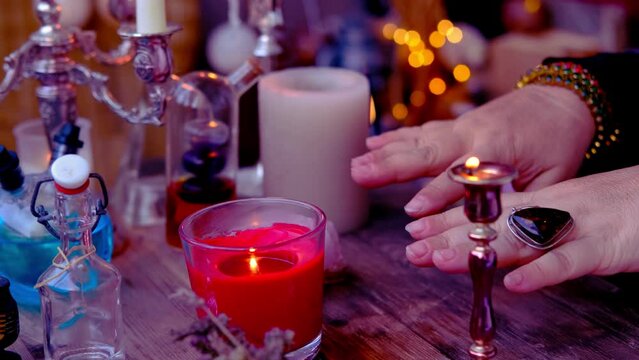 Female Fortuneteller or esoteric Oracle performs love spell with healing stones, ritual of removing spell of black magic, concept of divination, astrology and predicting the future
