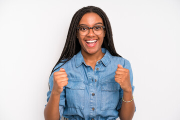 black young adult woman shouting triumphantly, laughing and feeling happy and excited while...