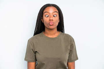 black young adult woman looking goofy and funny with a silly cross-eyed expression, joking and...